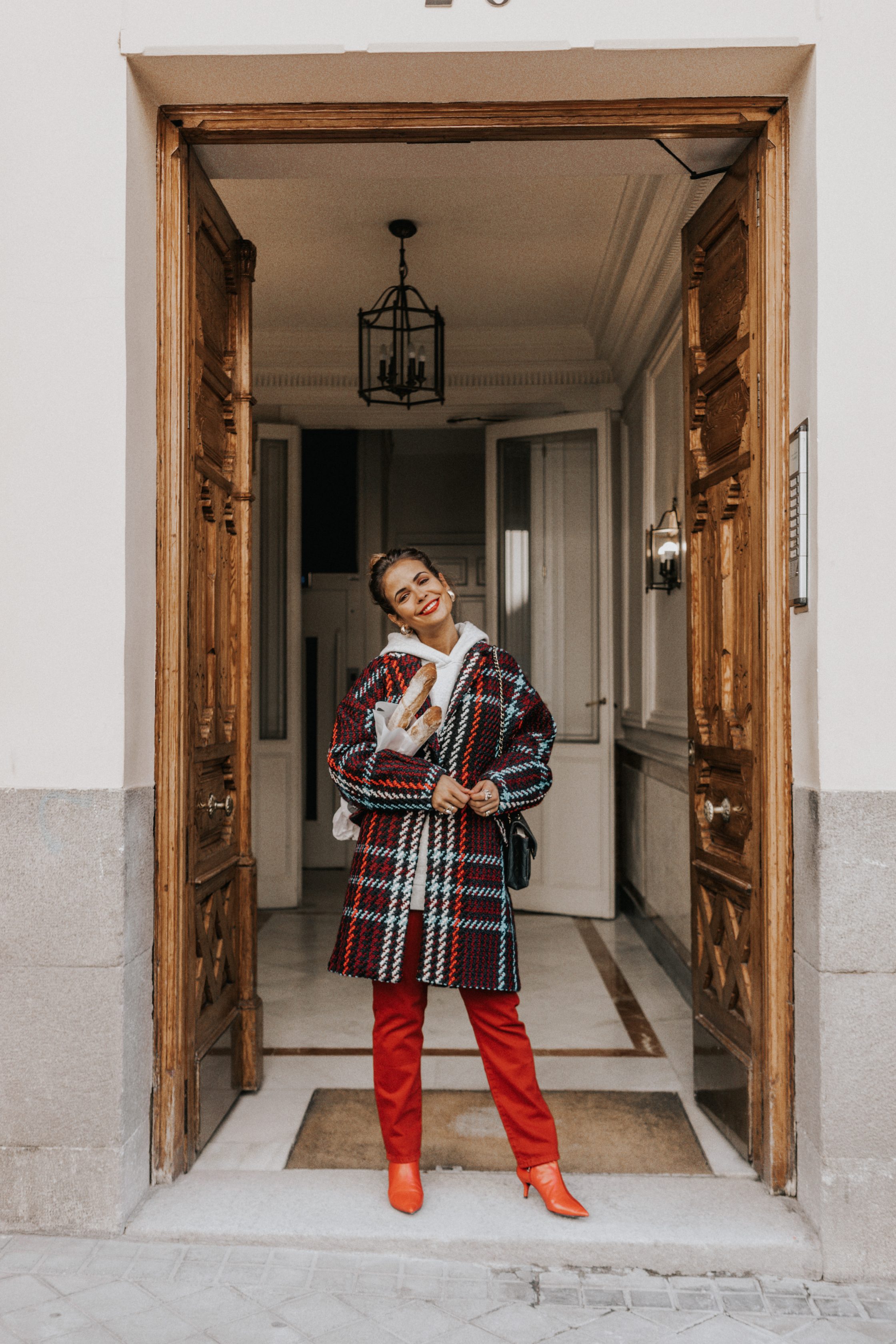 Sara of Collage Vintage wearing plaid coat and red trousers