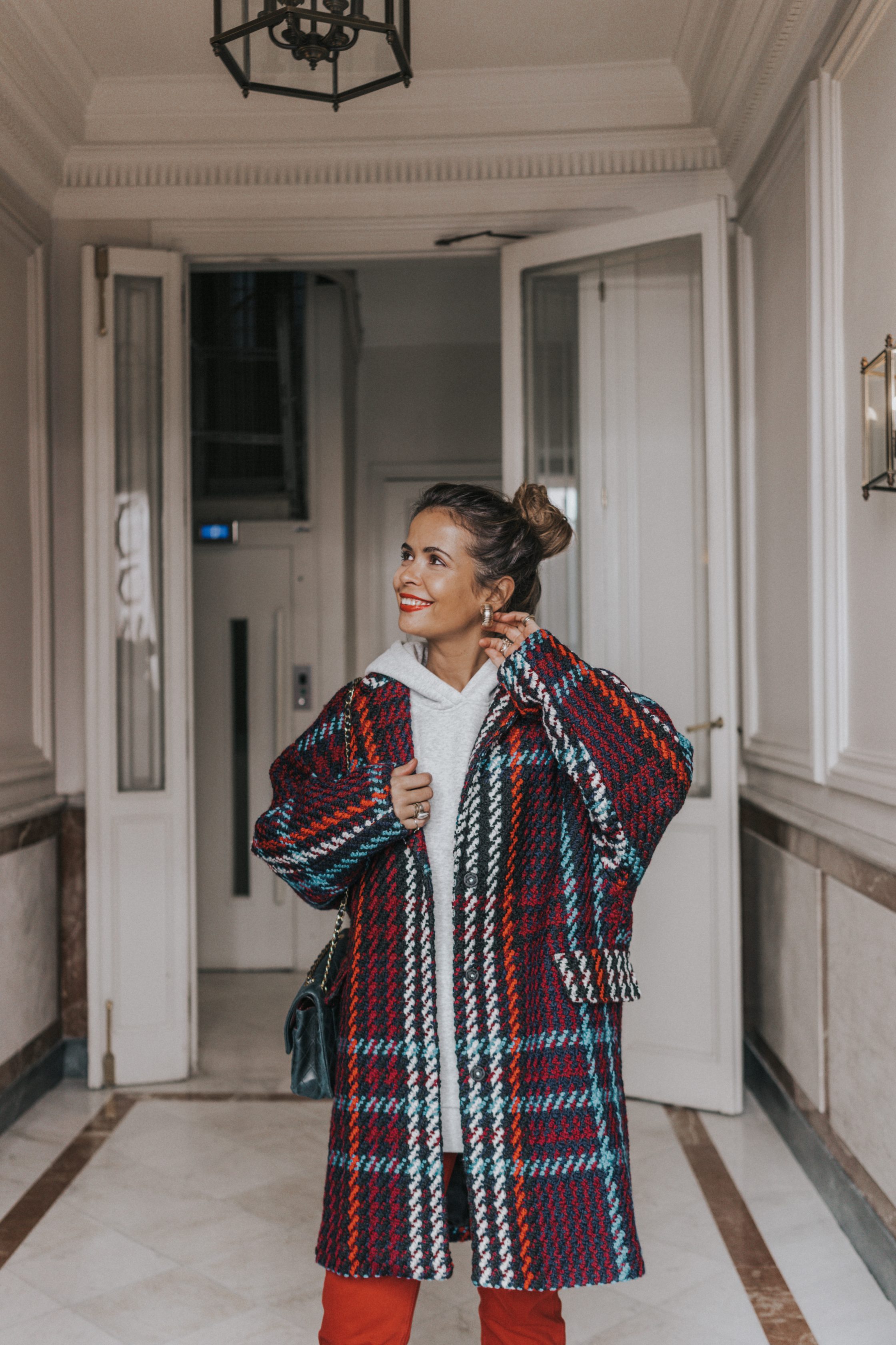 Sara of Collage Vintage wearing plaid coat and red trousers