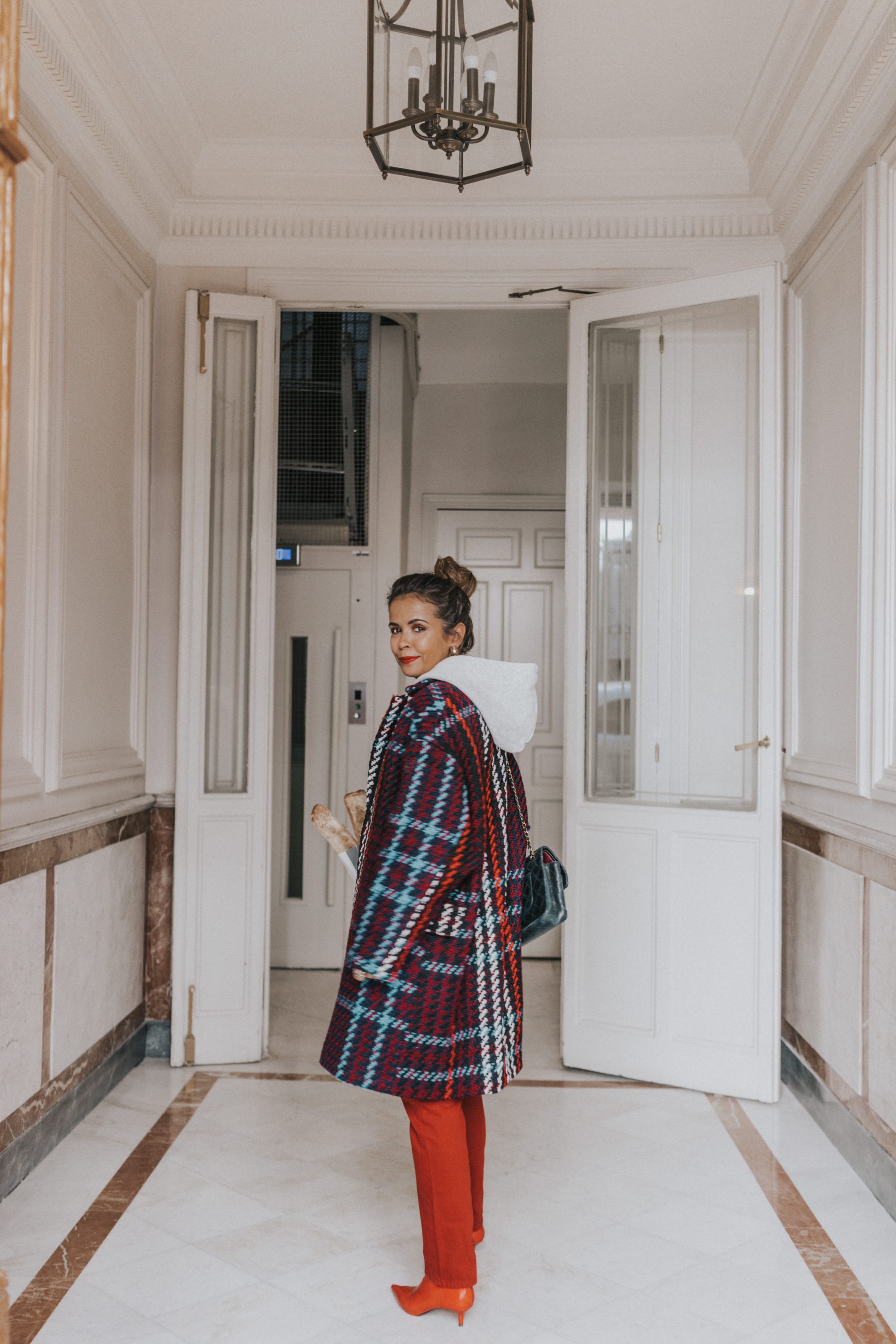 Sara of Collage Vintage wearing plaid coat and red trousers